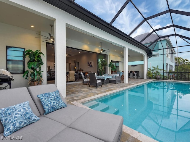 view of swimming pool with outdoor lounge area, a patio area, ceiling fan, and glass enclosure