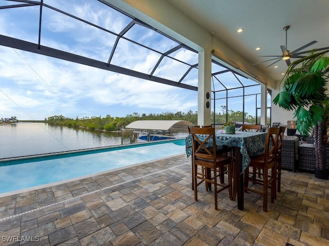 exterior space featuring a lanai, ceiling fan, and a water view