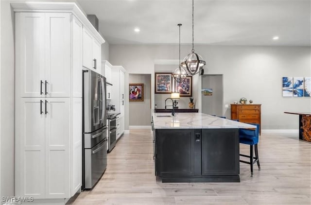 kitchen with light stone counters, a center island with sink, white cabinets, and stainless steel refrigerator with ice dispenser