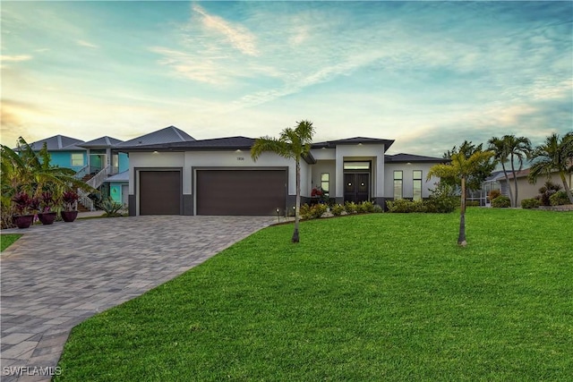 view of front of home featuring a lawn and a garage