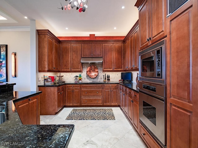 kitchen featuring decorative backsplash, crown molding, dark stone counters, and appliances with stainless steel finishes