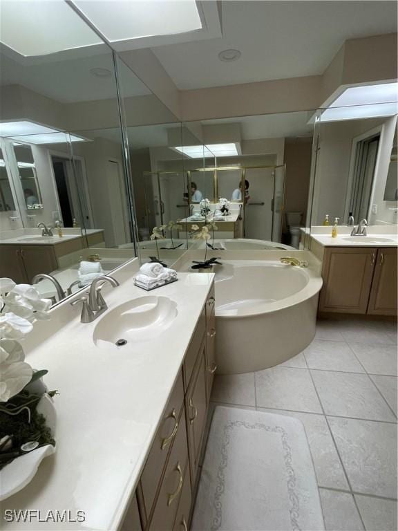 full bathroom with tile patterned flooring, vanity, separate shower and tub, and toilet