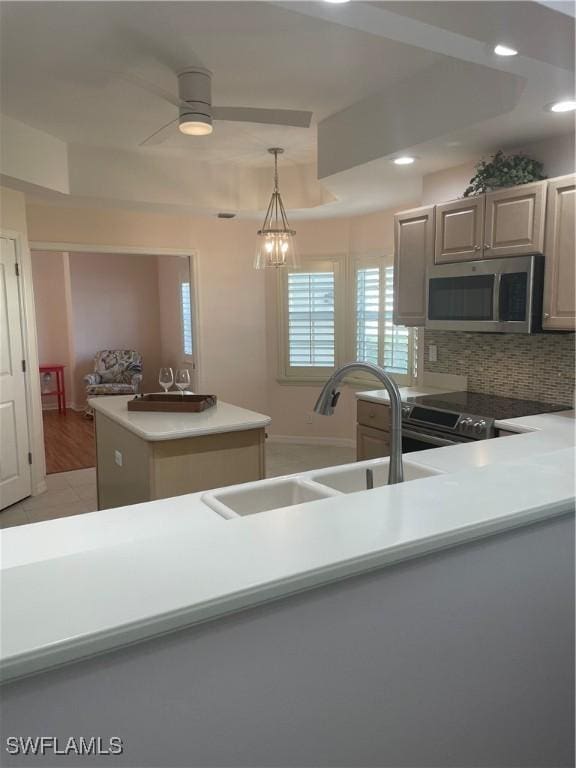 kitchen with ceiling fan with notable chandelier, sink, decorative backsplash, decorative light fixtures, and stainless steel appliances