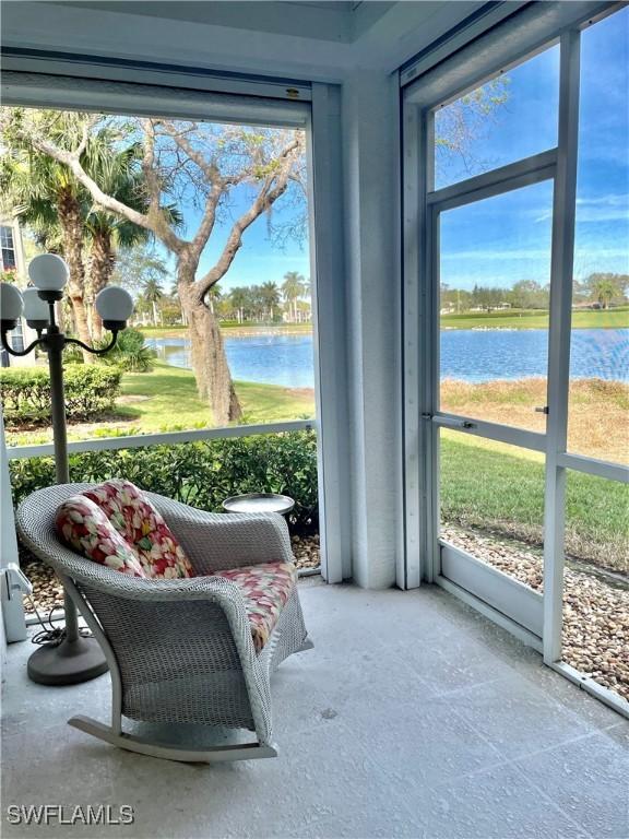 sunroom featuring a water view