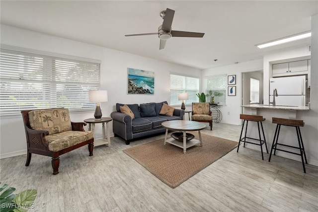 living room with light wood-type flooring and ceiling fan