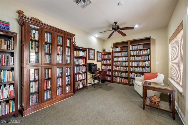 living area with ceiling fan and carpet