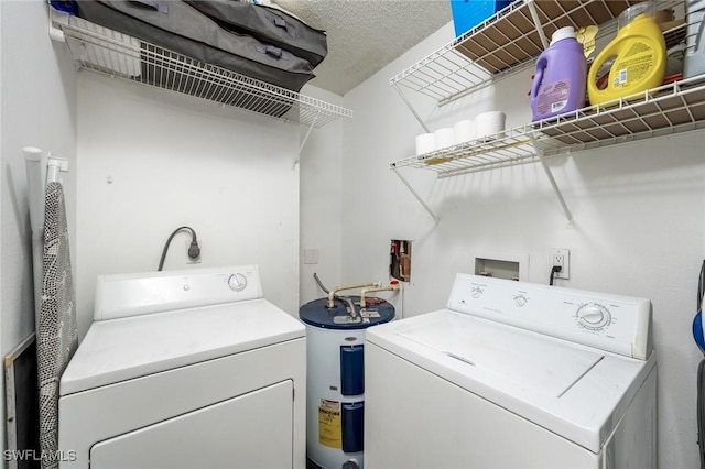 laundry room featuring a textured ceiling, water heater, and washing machine and dryer