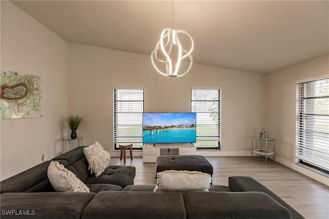 living area featuring lofted ceiling, an inviting chandelier, and wood finished floors