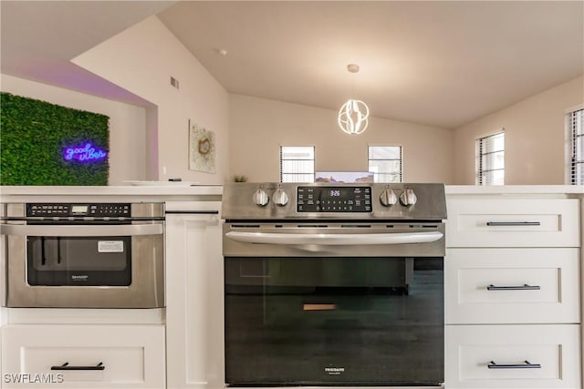 kitchen featuring lofted ceiling, white cabinetry, stainless steel oven, and a wealth of natural light