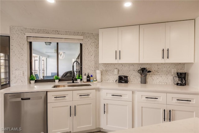 kitchen with a sink, white cabinetry, light countertops, and dishwasher