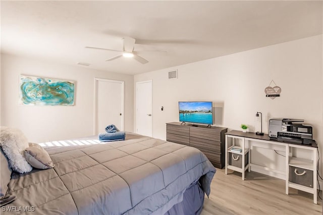 bedroom with light wood-style floors, visible vents, and a ceiling fan