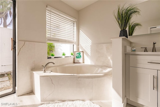 bathroom featuring vanity and a bath