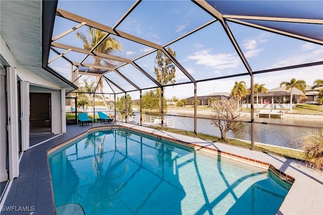 pool with a patio, a water view, and glass enclosure