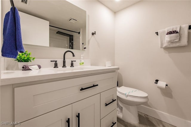 full bath with visible vents, baseboards, vanity, and toilet