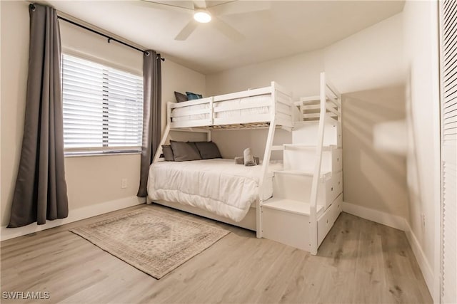 bedroom featuring ceiling fan, baseboards, and wood finished floors