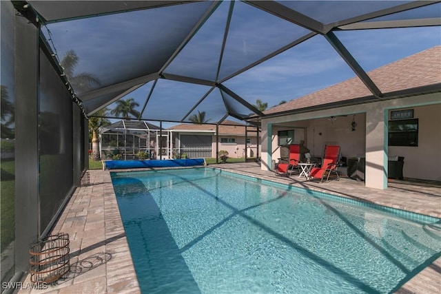 view of swimming pool featuring glass enclosure and a patio area