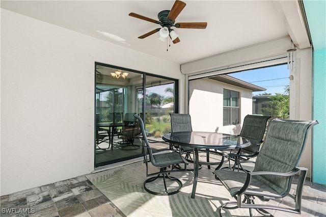 sunroom with a wealth of natural light and ceiling fan with notable chandelier