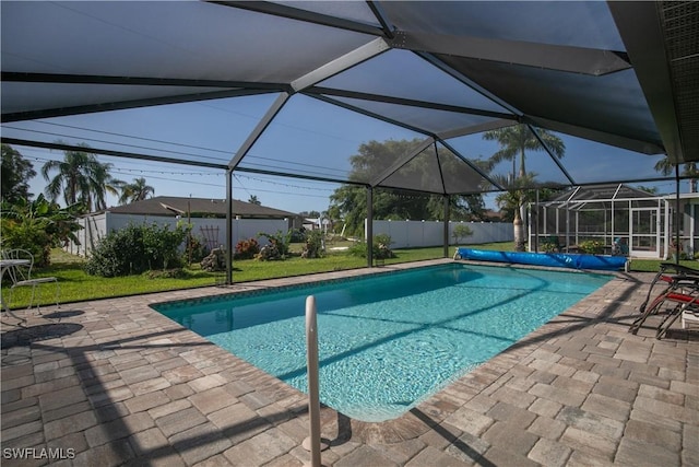 view of swimming pool with a lanai, a patio area, and a lawn