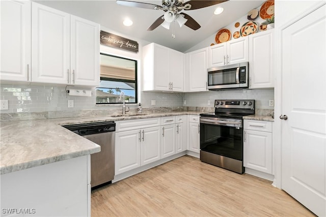 kitchen with white cabinetry, sink, stainless steel appliances, and lofted ceiling