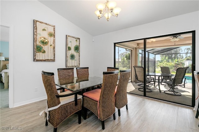 dining area with ceiling fan with notable chandelier, light hardwood / wood-style floors, and lofted ceiling