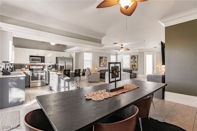 dining room with ceiling fan, crown molding, and light tile patterned flooring