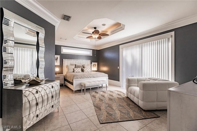 bedroom featuring a tray ceiling, ceiling fan, light tile patterned floors, and ornamental molding