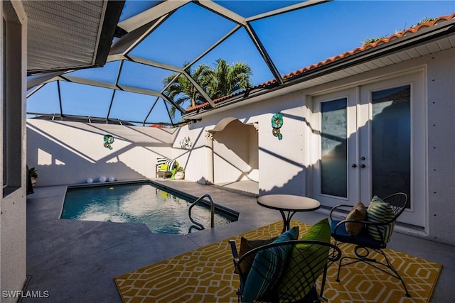 view of swimming pool with glass enclosure and a patio area