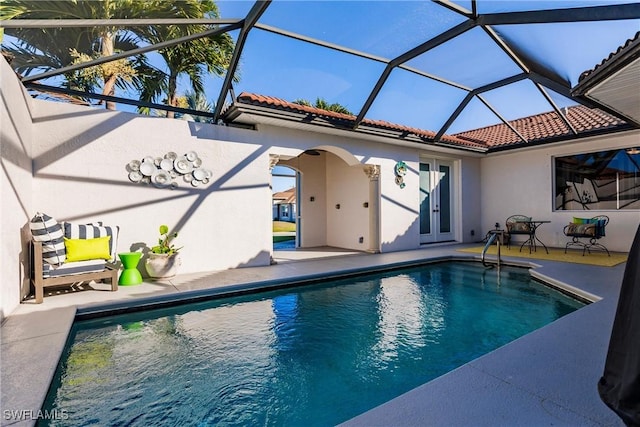 view of swimming pool with a lanai, french doors, and a patio