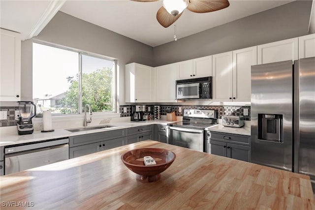 kitchen with white cabinets, stainless steel appliances, gray cabinetry, and butcher block counters