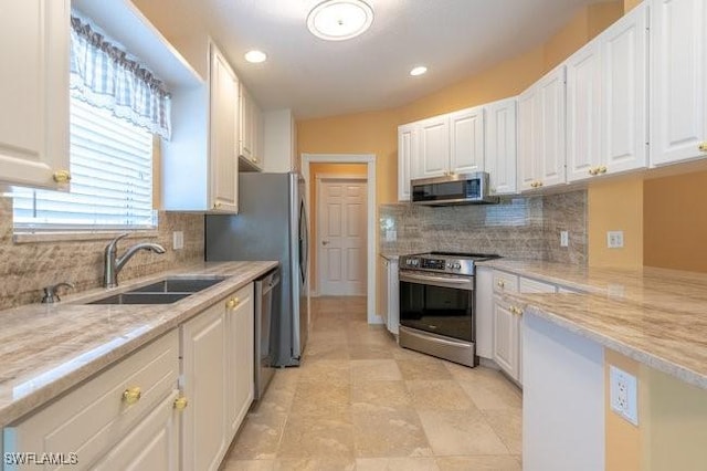 kitchen featuring light stone countertops, appliances with stainless steel finishes, white cabinetry, and sink