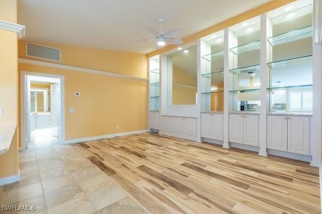 empty room featuring ceiling fan, built in features, light hardwood / wood-style floors, and lofted ceiling