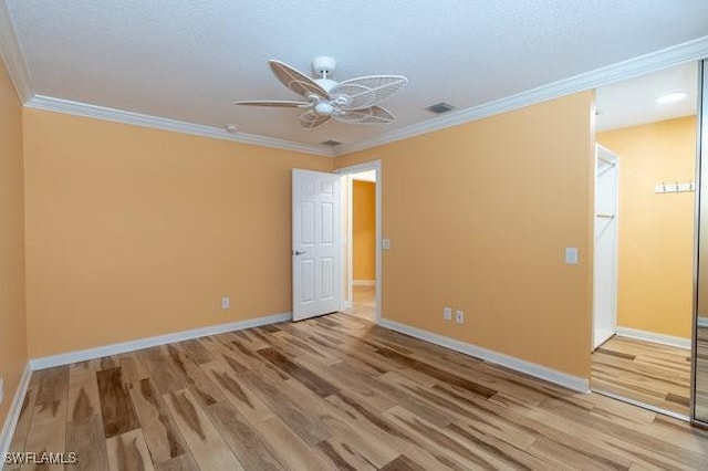 empty room with ceiling fan, hardwood / wood-style floors, and ornamental molding