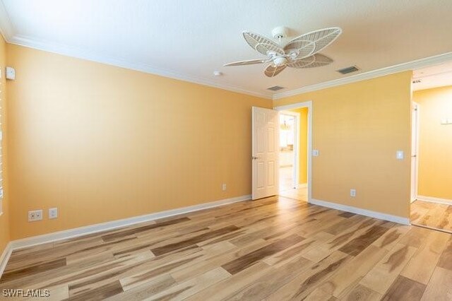 empty room featuring ceiling fan, light wood-type flooring, and ornamental molding