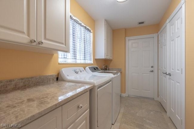 washroom with cabinets and independent washer and dryer