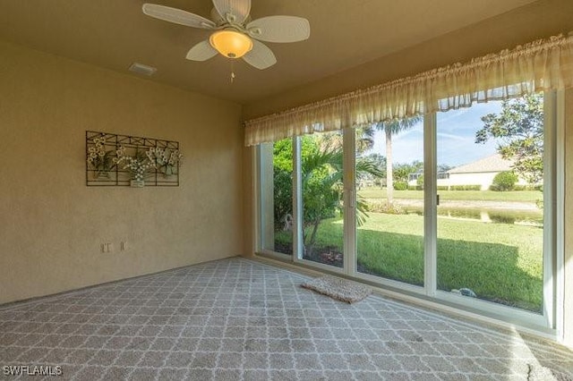 unfurnished sunroom with ceiling fan