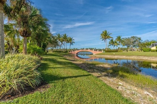 view of property's community with a lawn and a water view