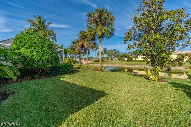 view of yard with a water view and glass enclosure