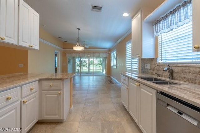 kitchen with sink, white cabinets, stainless steel dishwasher, and decorative light fixtures