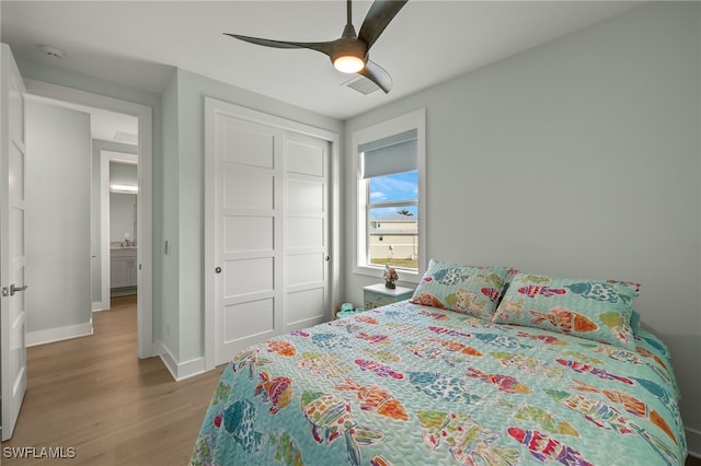 bedroom with ceiling fan, a closet, wood finished floors, and baseboards