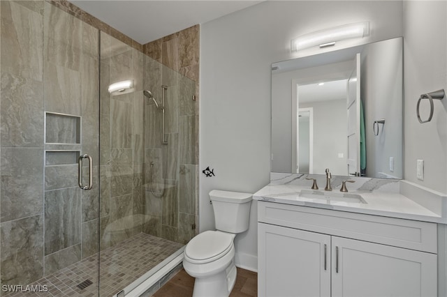 bathroom with baseboards, a shower stall, toilet, and vanity