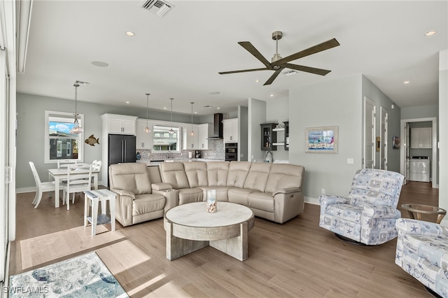 730 Matanzas Ct, Fort Myers Beach, FL 33931 - living area with washer / dryer, visible vents, light wood-type flooring, and a ceiling fan