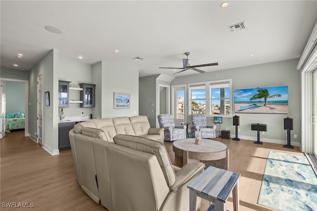 living room featuring recessed lighting, baseboards, visible vents, and light wood finished floors