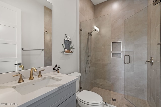 bathroom featuring a shower stall, toilet, and vanity