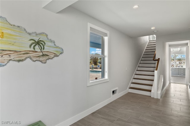 staircase with recessed lighting, wood finished floors, visible vents, and baseboards