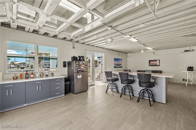 kitchen featuring light countertops, gray cabinets, freestanding refrigerator, and a ceiling fan