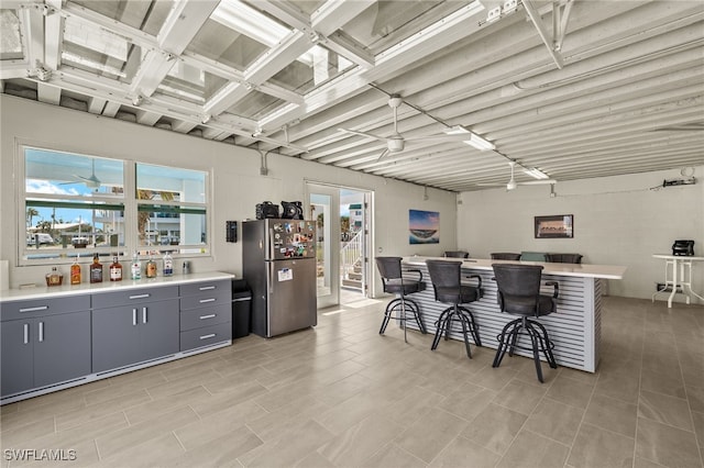 730 Matanzas Ct, Fort Myers Beach, FL 33931 - kitchen featuring gray cabinets, light countertops, freestanding refrigerator, and a breakfast bar