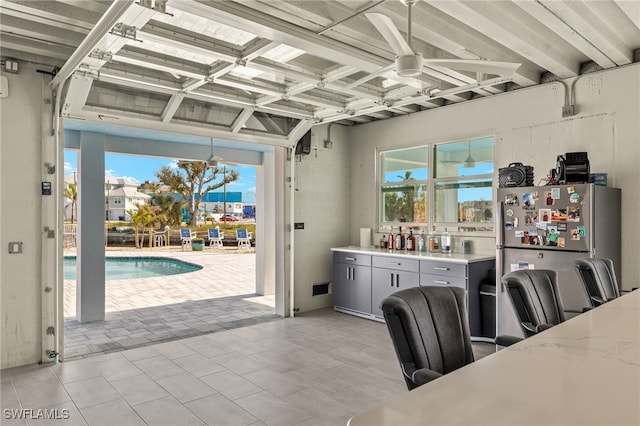 interior space featuring plenty of natural light, light countertops, a ceiling fan, and freestanding refrigerator