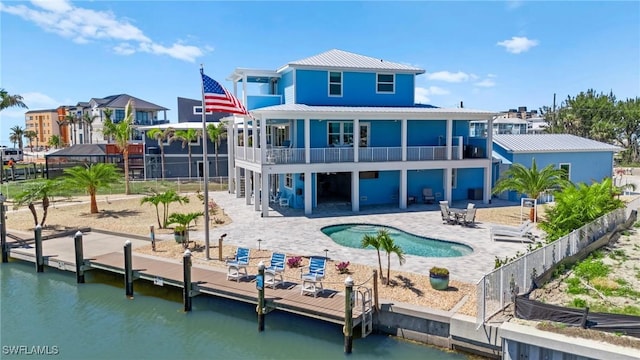 730 Matanzas Ct, Fort Myers Beach, FL 33931 - rear view of house featuring a water view, a patio, metal roof, and a balcony