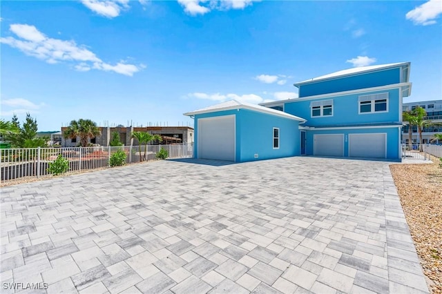 730 Matanzas Ct, Fort Myers Beach, FL 33931 - view of front of home featuring an attached garage, driveway, stucco siding, and fence