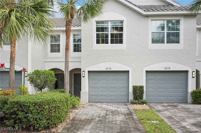 16118 Ravina Way, Naples, FL 34110 - view of front facade with stucco siding, an attached garage, driveway, and a tile roof